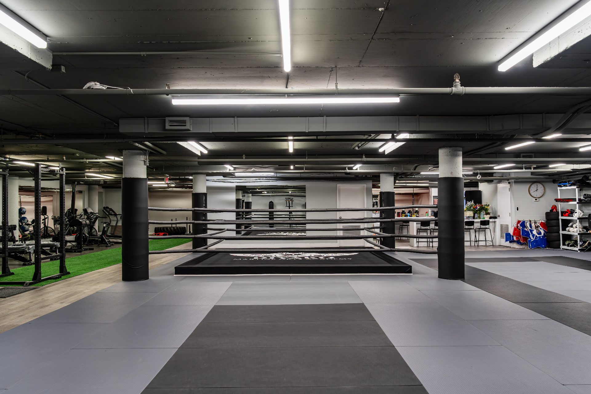 Symmetrical view through the boxing ring with mats, racks and coffee bar