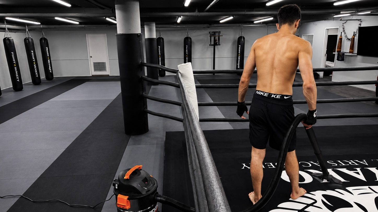 DKM Academy training floor with boxing ring and heavy bags