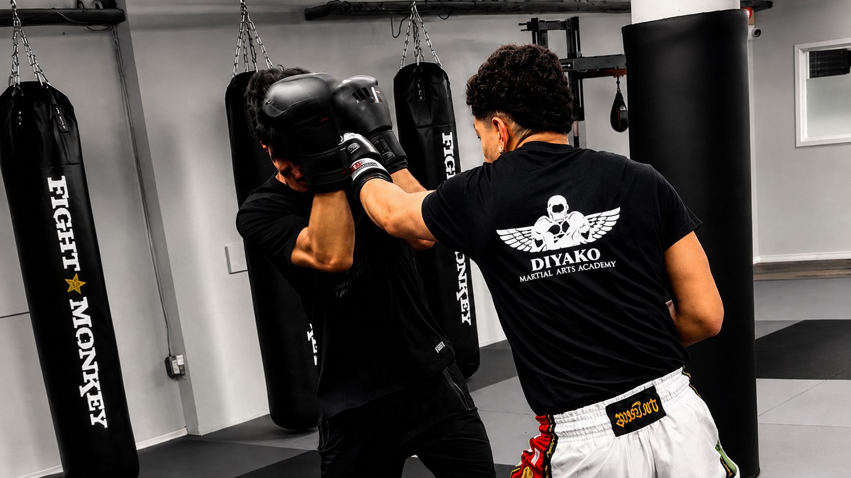 Two DKM fighters sparring in front of the heavy bag wall